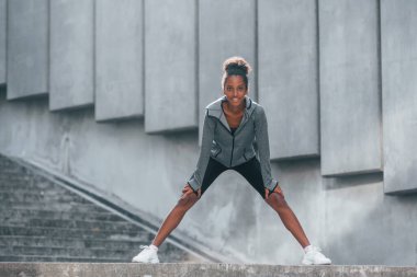 Spor anlayışı. Spor elbiseli genç Afrikalı Amerikalı kadın gündüzleri dışarıda antrenman yapıyor..