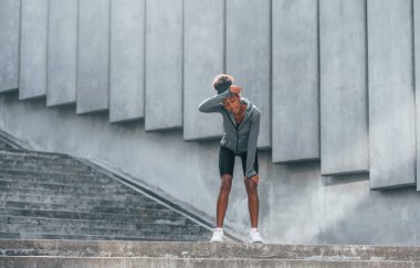 Spor anlayışı. Spor elbiseli genç Afrikalı Amerikalı kadın gündüzleri dışarıda antrenman yapıyor..