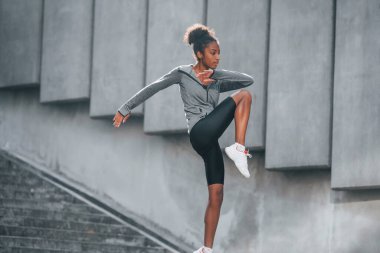Spor anlayışı. Spor elbiseli genç Afrikalı Amerikalı kadın gündüzleri dışarıda antrenman yapıyor..