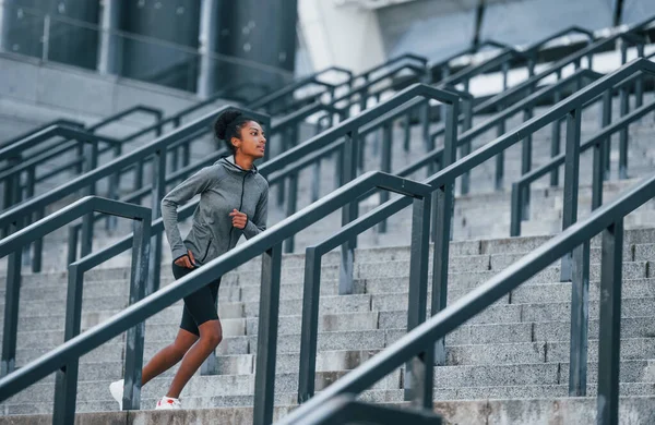 活跃的跑步者身穿运动服的年轻非洲裔美国妇女白天在室外锻炼 — 图库照片