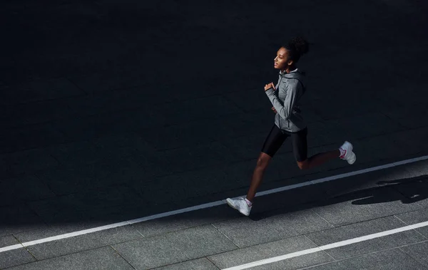 跑得快身穿运动服的年轻非洲裔美国妇女白天在室外锻炼 — 图库照片