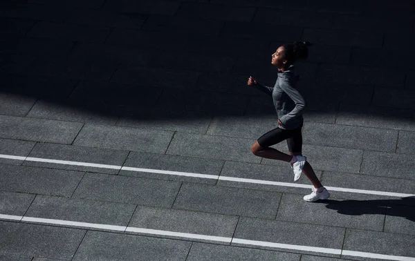 跑得快身穿运动服的年轻非洲裔美国妇女白天在室外锻炼 — 图库照片