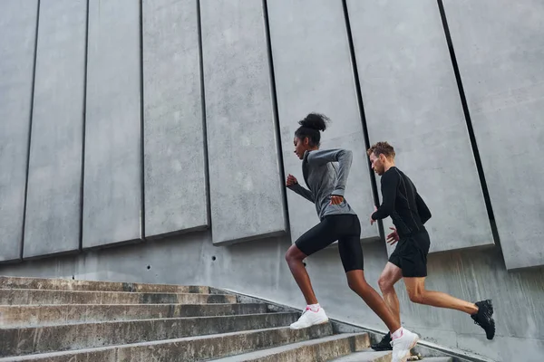 European man and african american woman in sportive clothes have workout together.