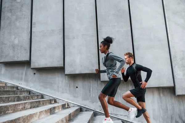 穿着运动服的欧洲男人和非洲女人一起锻炼 — 图库照片