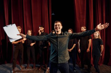 Adam rolüne çalışıyor. Tiyatroda prova yapan koyu renkli elbiseli bir grup aktör..