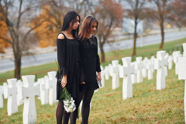 Tem Flores Duas Mulheres Jovens Roupas Pretas Visitando Cemitério Com — Fotografia de Stock