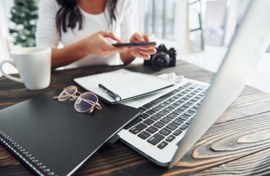 Gündüz vakti ofiste çalışan genç bayan serbest çalışanın yakın görüntüsü..