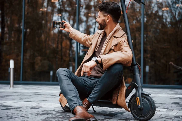 Zit Elektrische Scooter Jonge Man Model Modieuze Kleding Buiten Stad — Stockfoto