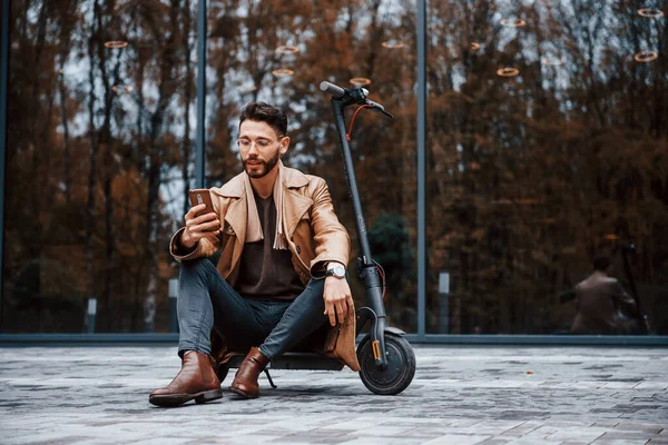 Zit Elektrische Scooter Jonge Man Model Modieuze Kleding Buiten Stad — Stockfoto