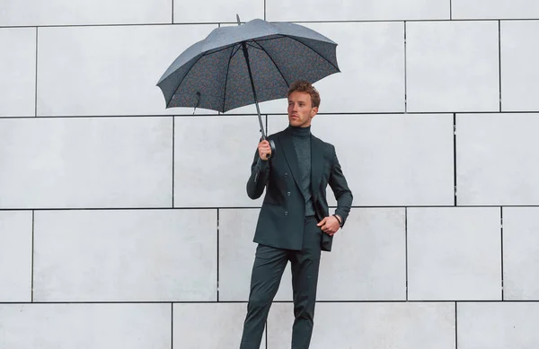 Молодой Человек Формальной Одежде Зонтиком Стоит Стены Открытым Небом Зонтиком — стоковое фото
