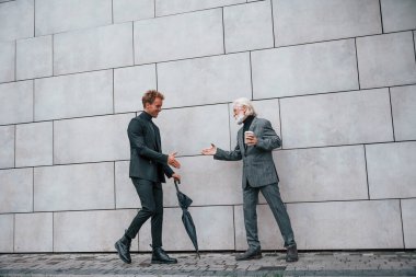 Buluşma var. Zarif giyinmiş son sınıf öğrencisi olan genç adam açık havada birlikte. İş kavramı.