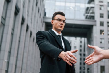 Tokalaşıyorum. Siyah takım elbiseli ve kravatlı iş adamı şehir dışında..