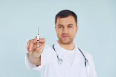 Üniformalı doktor stüdyoda duruyor..