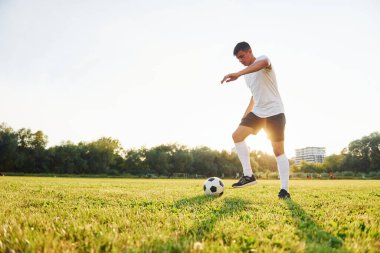 Sadece bir kişi. Genç futbolcu spor sahasında antrenman yapıyor..