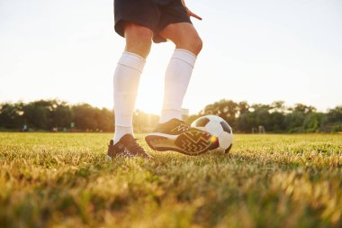 Manzarayı kapat. Genç futbolcu spor sahasında antrenman yapıyor..