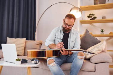 Yaratıcılık kavramı. Gündelik giysiler içinde ve akustik gitarlı bir adam içeride..