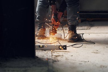 Kesici aletle insanın ellerini ve bacaklarını kapat. Metalle çalışmak.