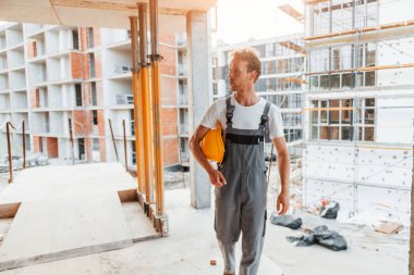 Büyük proje. Gündüz vakti inşaatta üniformalı genç bir adam çalışıyor..