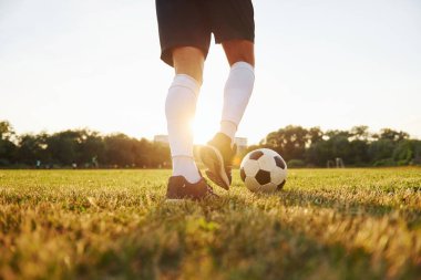 Manzarayı kapat. Genç futbolcu spor sahasında antrenman yapıyor..