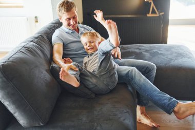 Oynamak ve eğlenmek. Baba ve oğul evde birlikte..