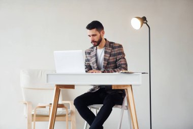 Laptop kullanıyor. Takım elbiseli genç bir iş adamı. Başarı kavramı.