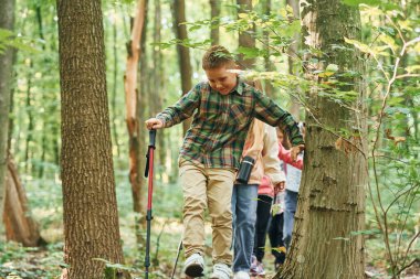 Yeşil ormanda. Çocuklar yazın gündüz vakti dışarıda yürüyorlar..