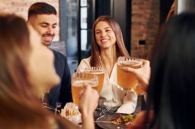 Eğleniyorum. Bir grup genç arkadaş barda birlikte oturup bira içiyorlar..