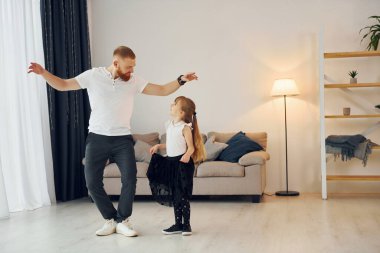 Yoga pozları. Baba ve küçük kızı evde birlikteler..