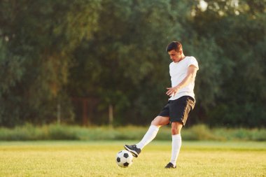 Profesyonelce. Genç futbolcu spor sahasında antrenman yapıyor..