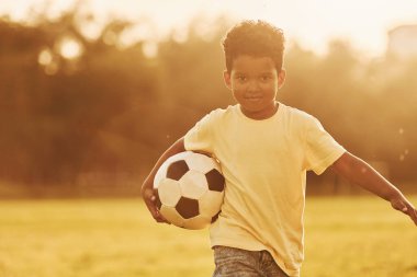 Genç futbolcu. Afrikalı Amerikalı çocuk yaz günlerinde tarlada eğleniyor..