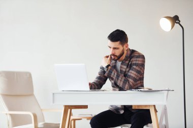 Laptop kullanıyor. Takım elbiseli genç bir iş adamı. Başarı kavramı.