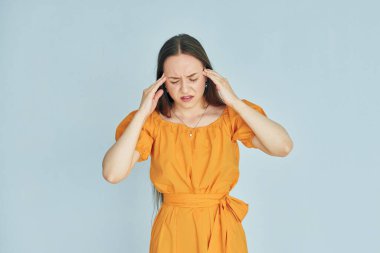 Günlük giysiler içinde baş ağrısı çeken genç bir kadın..