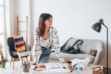 Masanın yanında duruyor. Genç bayan serbest çalışan gündüzleri evdedir..