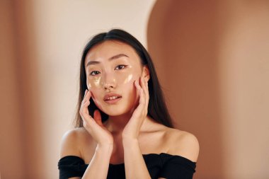 Deri temizleme. Genç ciddi Asyalı kadın içeride duruyor..