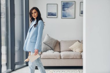 Ev içi oda. Modaya uygun giyinen Avrupalı kadın içeride poz veriyor..