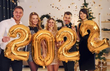 2022 yılı. Bir grup insan içeride yeni yıl partisi veriyor..