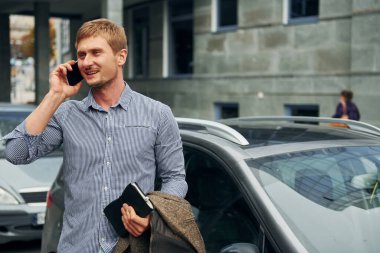 Telefonla konuşuyorum. Gündüz vakti şehirde gezen bir adam..