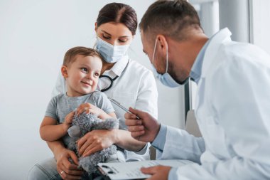 Nitelikli yardım. Beyaz önlüklü iki doktor klinikte birlikte çalışıyorlar..