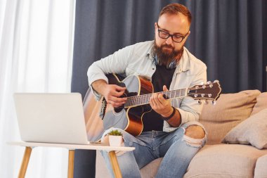 Rahatlamış hissediyorum. Gündelik giysiler içinde ve akustik gitarlı bir adam içeride..