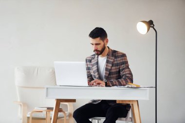 Laptop kullanıyor. Takım elbiseli genç bir iş adamı. Başarı kavramı.