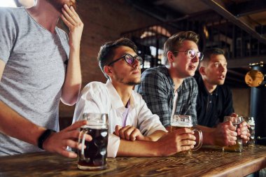 Alkolik içecekler. Barda sıradan giyinmiş insanlar oturuyor..