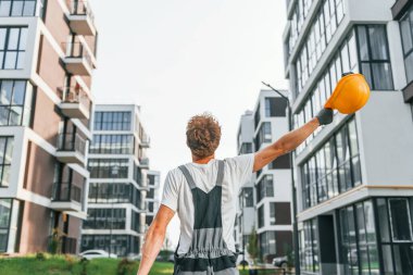 İş raporları. Gündüz vakti inşaatta üniformalı genç bir adam..