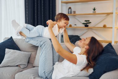 Kanepede oynuyorum. Anne ve küçük kızı evde birlikteler..