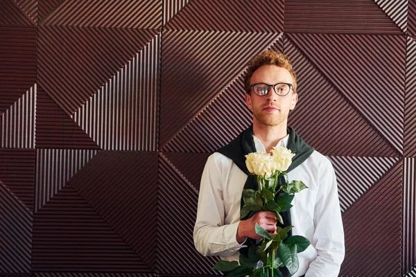 Man holds flowers. Indoors of new modern luxury restaurant.