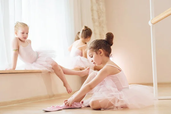 女孩坐在地板上 通过练习舞步准备表演的小芭蕾舞演员 — 图库照片