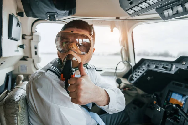 In oxygen mask. Pilot on the work in the passenger airplane. Preparing for takeoff.