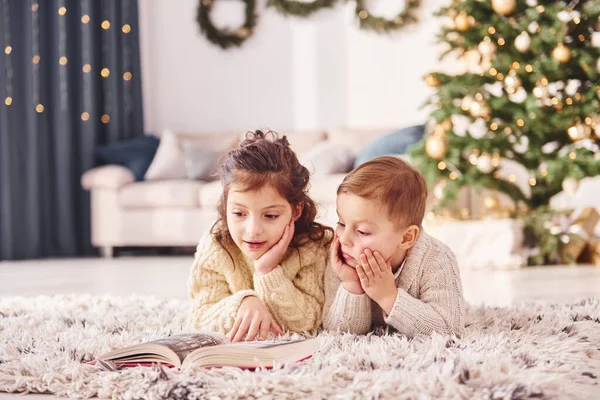 躺在地上 小弟弟和小妹妹在圣诞节装饰房间里 — 图库照片