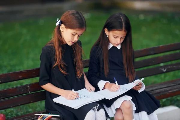 Sitzen Und Lesen Zwei Schülerinnen Stehen Gemeinsam Der Nähe Eines — Stockfoto