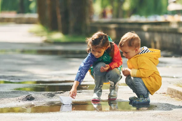 Birikintisinde Çocuklar Yağmurdan Sonra Parkta Eğleniyorlar — Stok fotoğraf