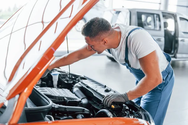 Orange Colored Car Man Uniform Repairing Broken Automobile Indoors — Stock Photo, Image